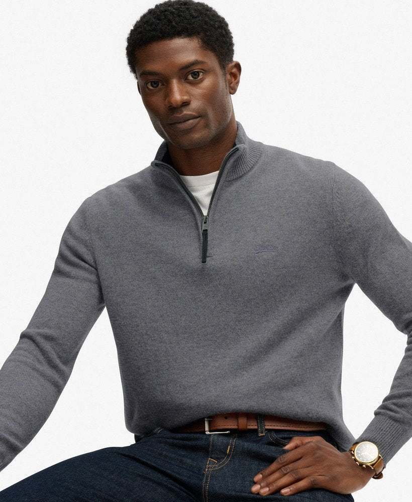 Man wearing a gray quarter-zip sweater with a white background