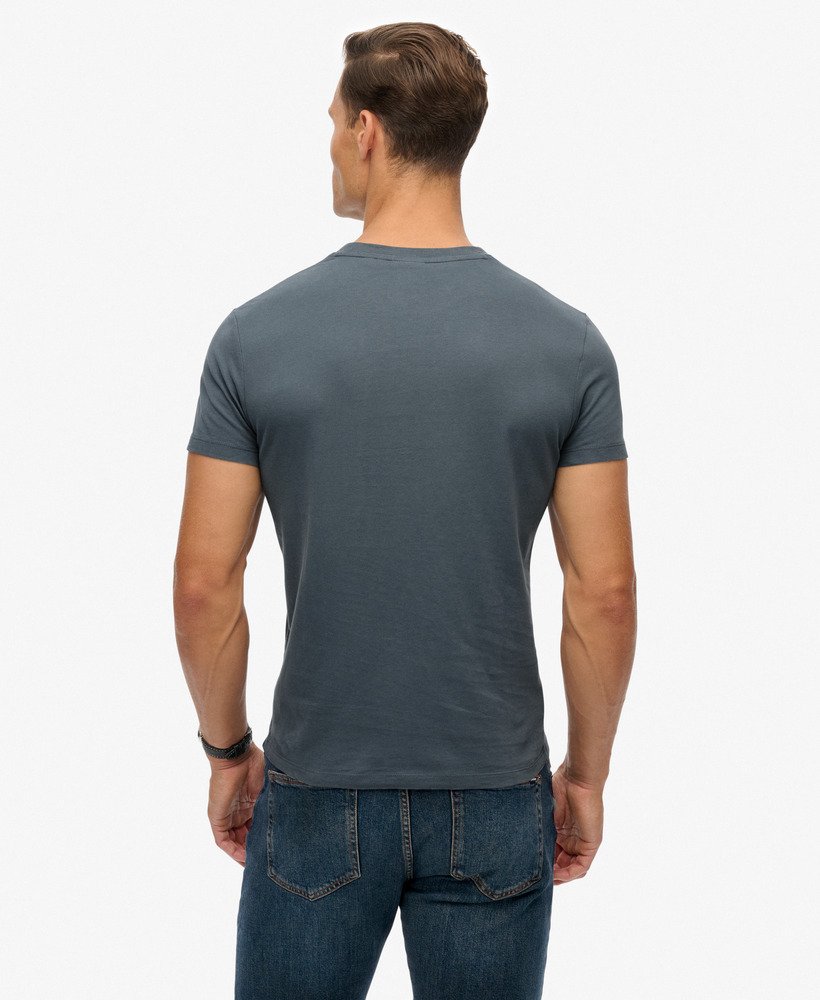 Man wearing a gray t-shirt and blue jeans on a white background