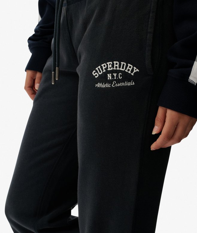 Navy sweatpants with 'Superdry N.Y.C. Athletic Essentials' logo on a white background