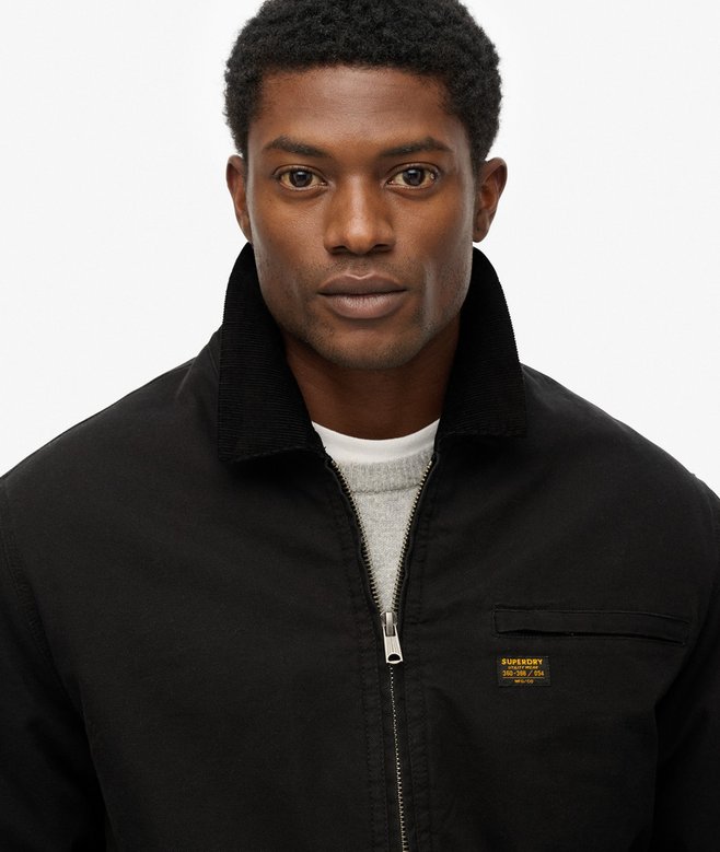 Man wearing a black jacket with a brand logo on a white background