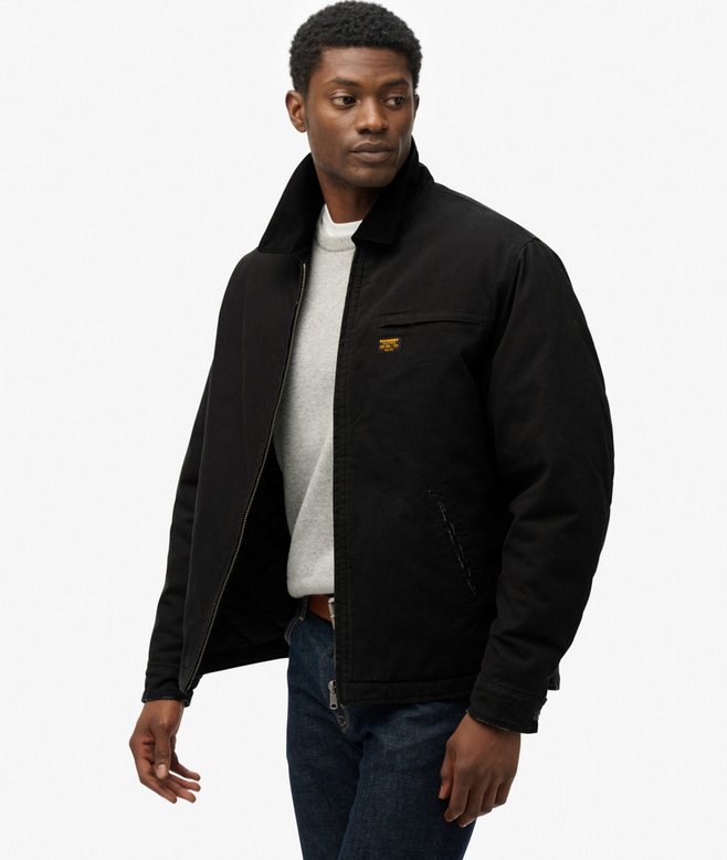 Man wearing a black jacket with a brand logo on a white background