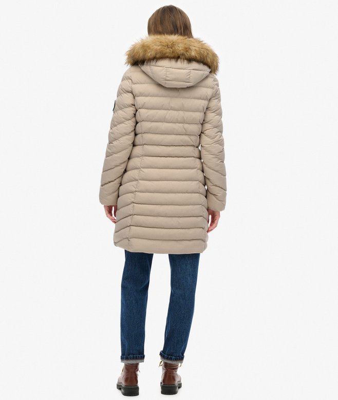 Beige winter coat with fur hood worn by a person on a white background