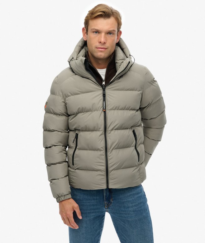 Man wearing a light green puffer jacket on a white background