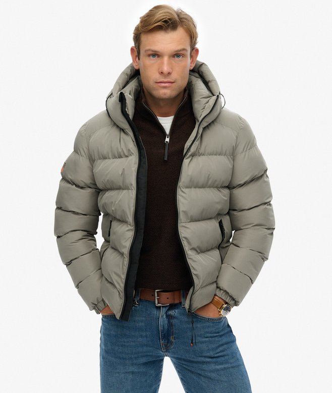 Man wearing a light green puffer jacket on a white background