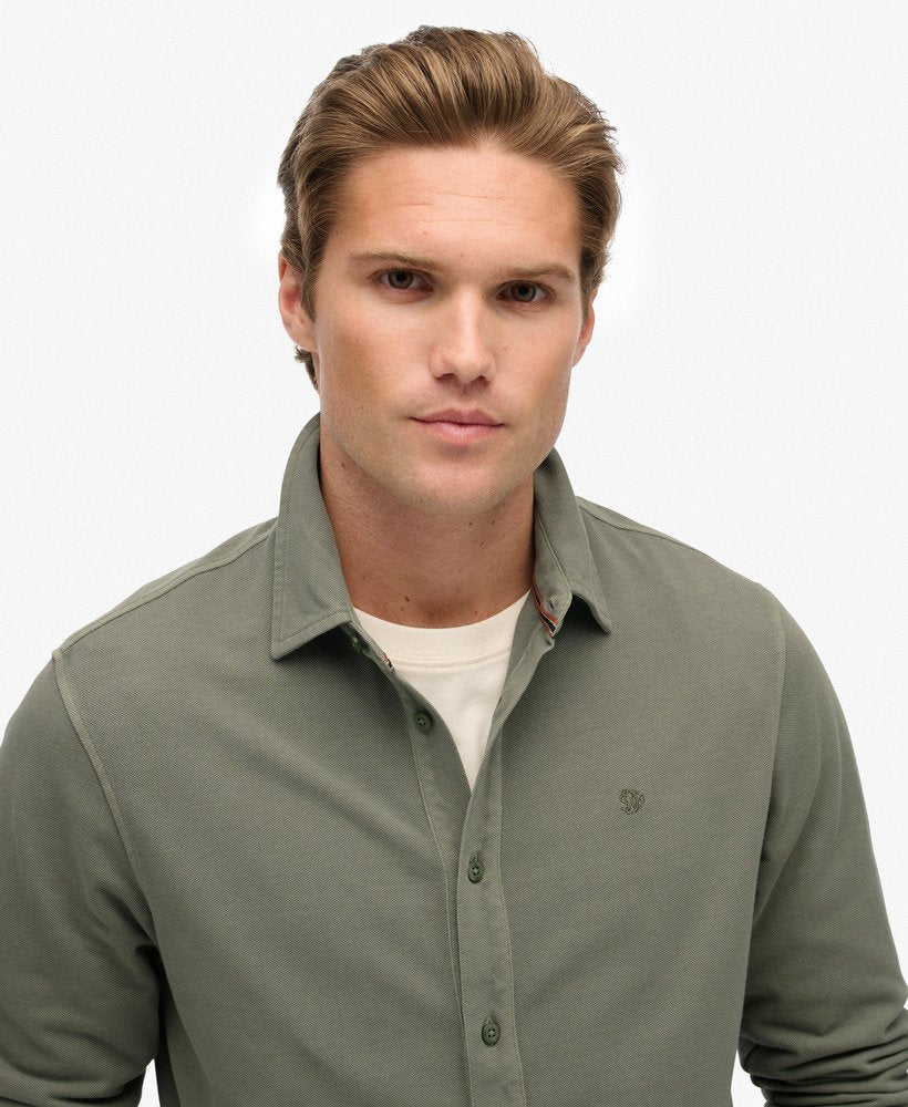 Man wearing a green long-sleeve shirt on a white background