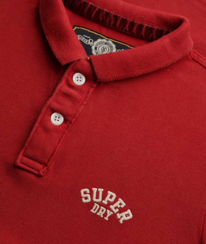 Red polo shirt with 'Super Dry' logo and brand label on collar