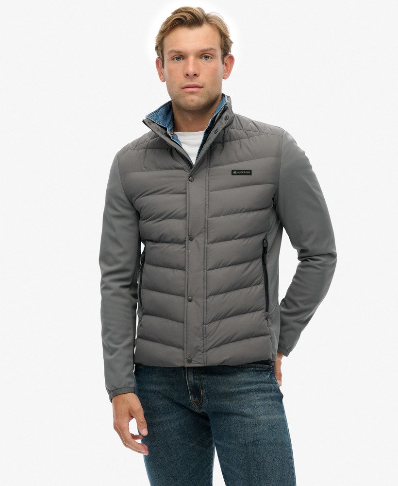 Man wearing a gray puffer jacket on a white background