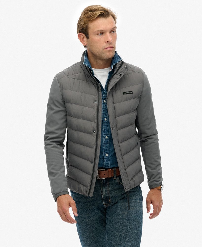 Man wearing a gray puffer jacket on a white background