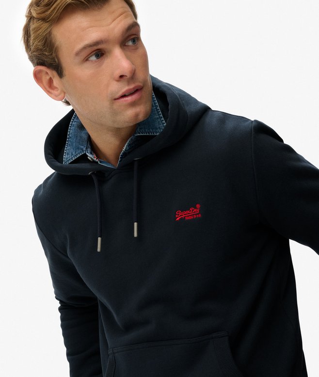 Man wearing a navy hoodie with a red logo on a white background