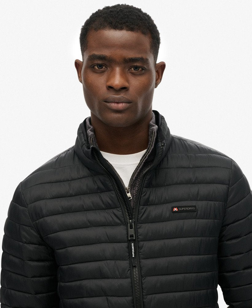 Man wearing a black puffer jacket on a white background