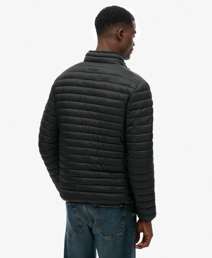 Man wearing a black quilted jacket on a white background