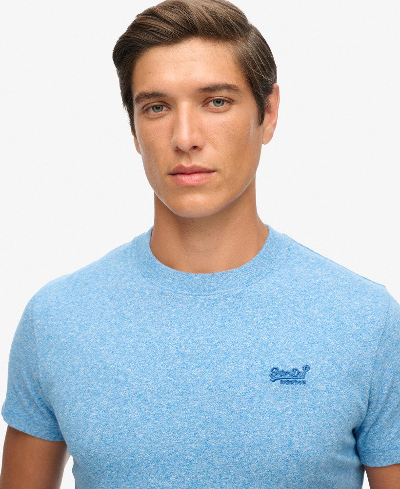 Man wearing a blue t-shirt with a Superdry logo on a white background