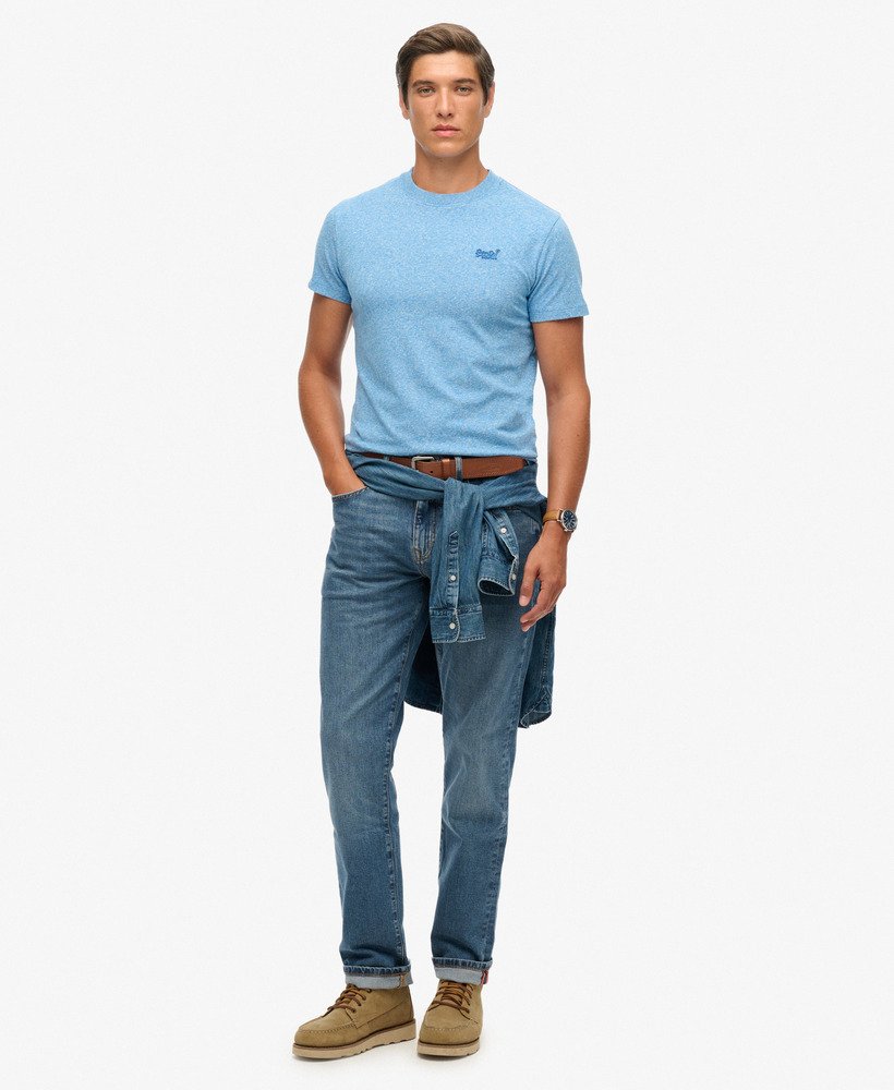 Man wearing a blue t-shirt and jeans on a white background