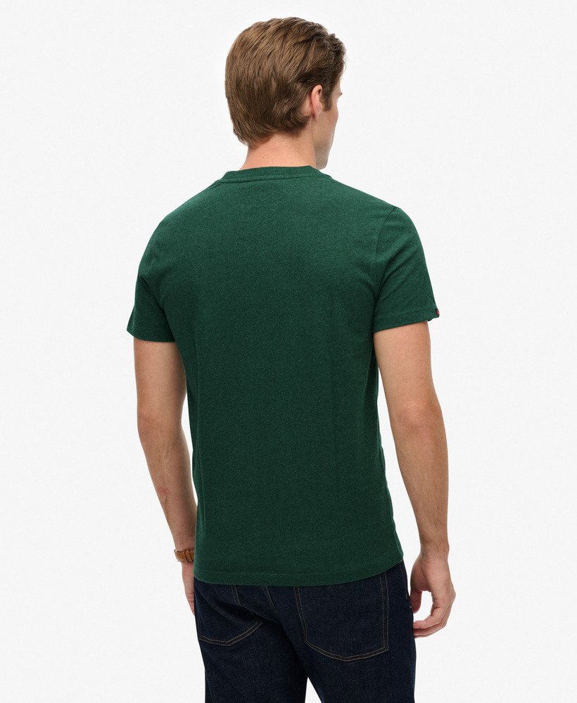 Man wearing a green t-shirt with a brand logo on a white background
