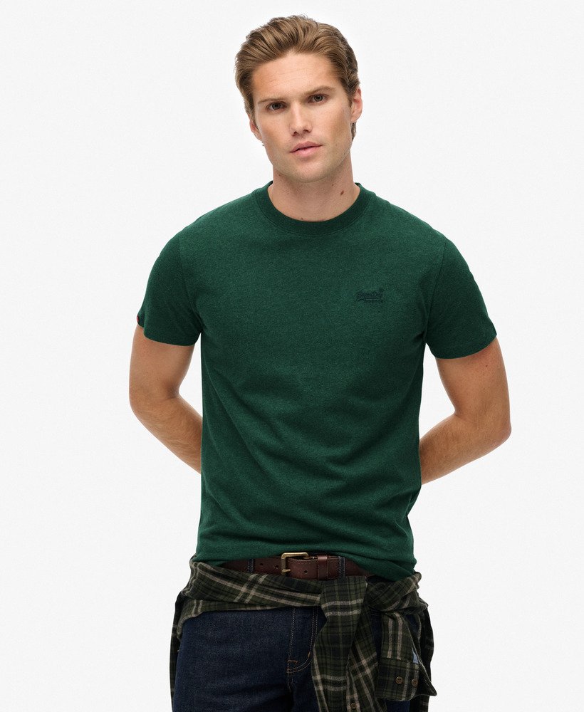 Man wearing a green t-shirt with a logo on a white background