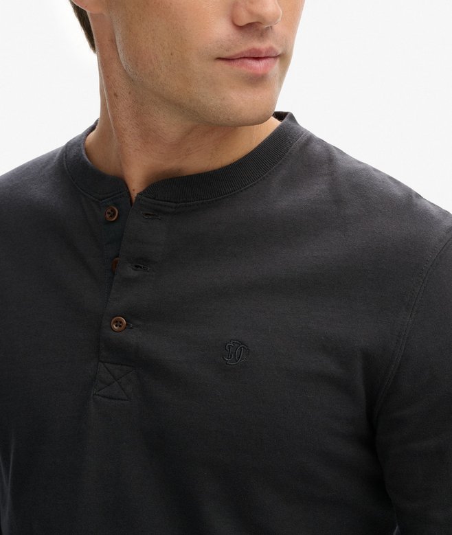 Close-up of a person wearing a black long-sleeve shirt with buttons on a white background