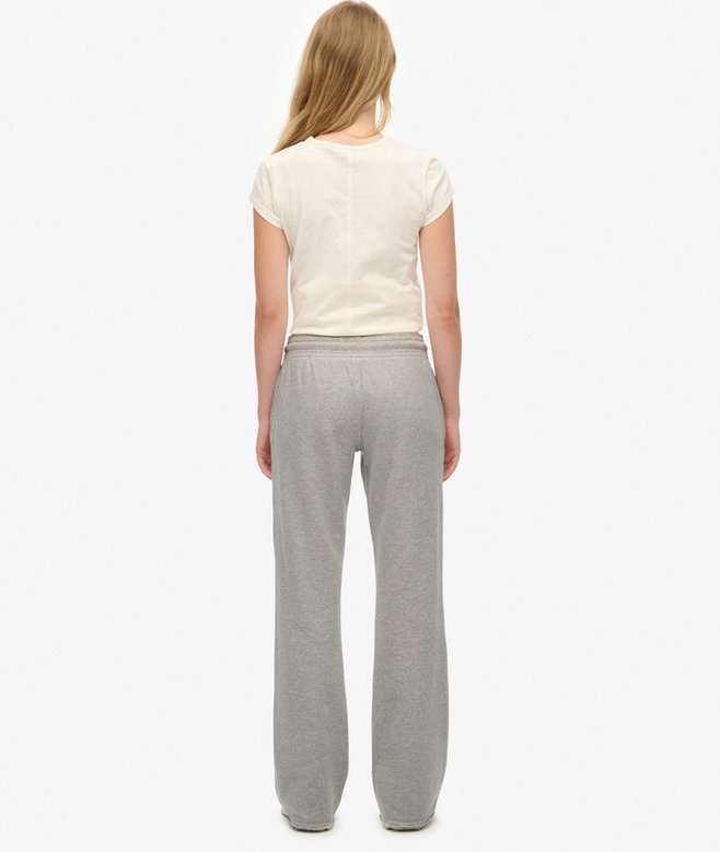 Person wearing a white top and gray pants on a white background