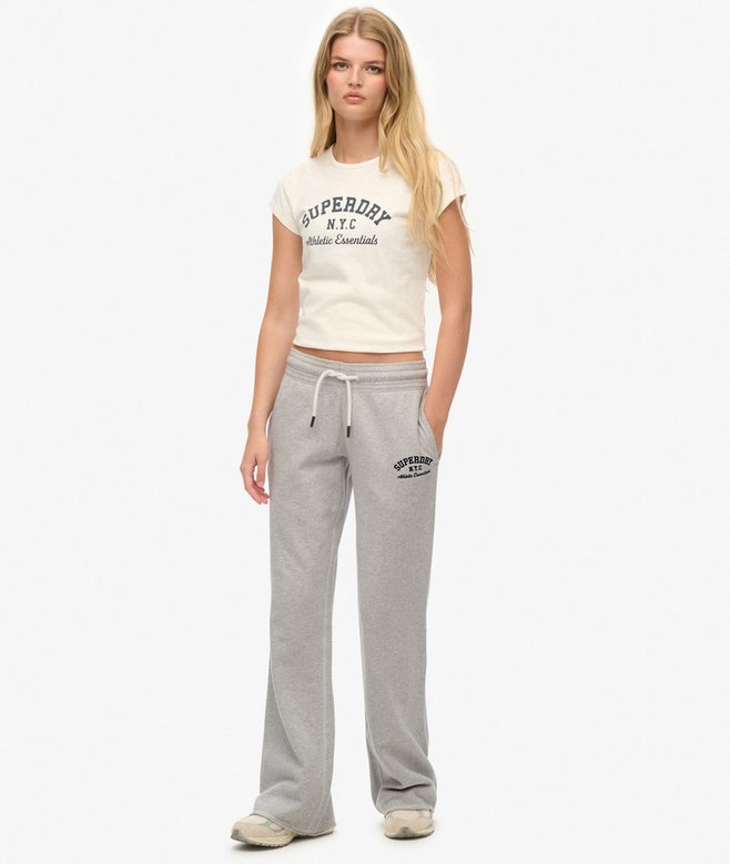 Woman wearing a white t-shirt and gray sweatpants with Superdry branding on a white background