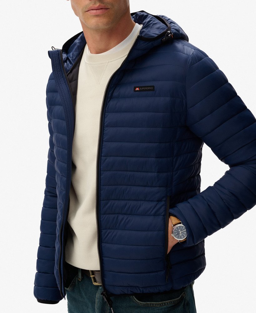 Man wearing a blue puffer jacket on a white background