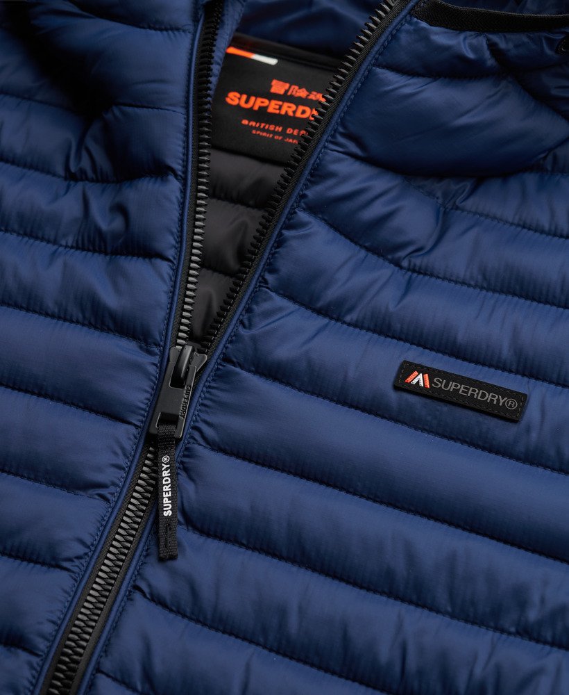 Close-up of a blue puffer jacket with Superdry branding.