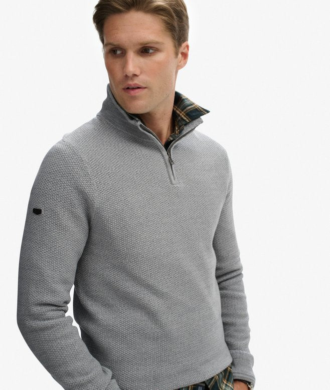 Man wearing a gray sweater with a white background