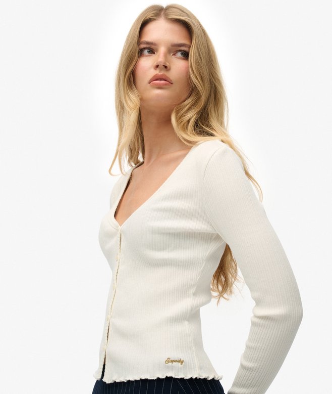 Woman wearing a white cardigan on a plain background