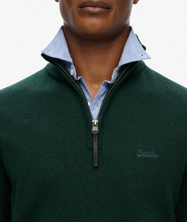 Man wearing a green sweater with a zipper and light blue shirt underneath, on a white background.