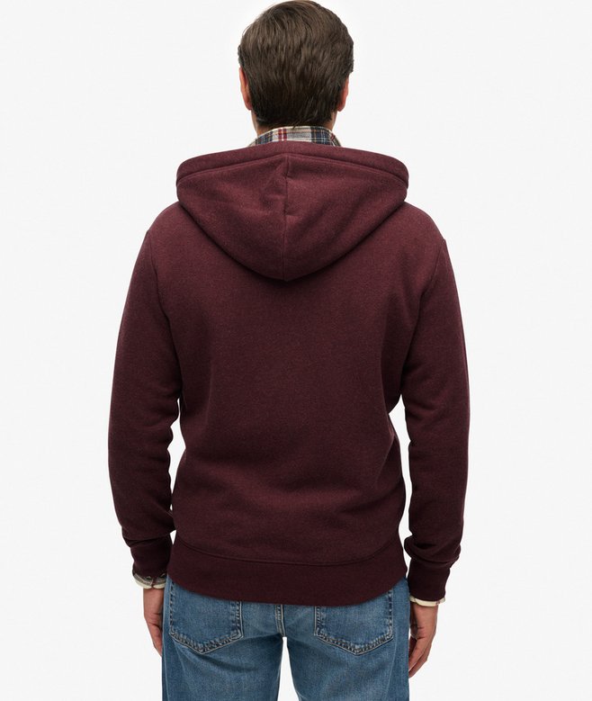 Person wearing a maroon hoodie and blue jeans on a white background