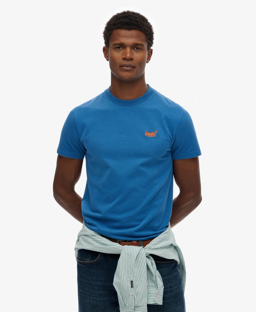 Man wearing a blue t-shirt with a logo on a white background