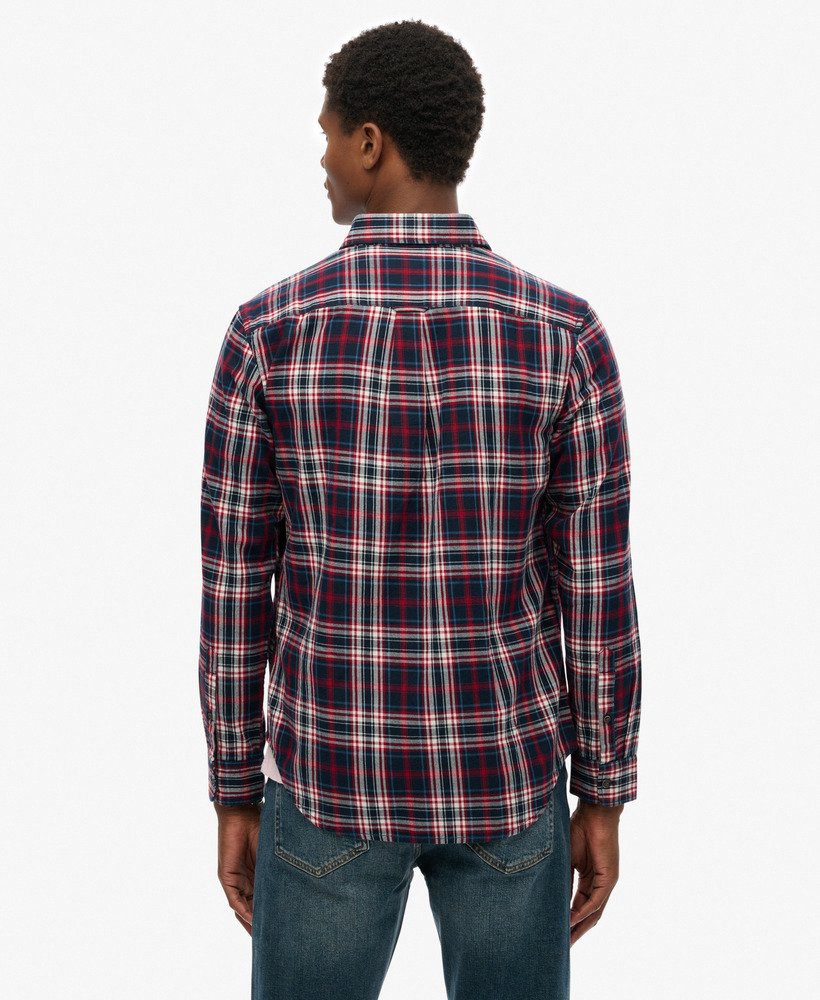 Person wearing a red and blue plaid shirt on a white background