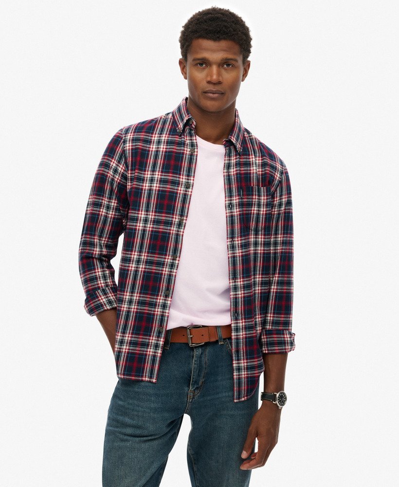 Man wearing a plaid shirt over a white t-shirt with jeans on a white background