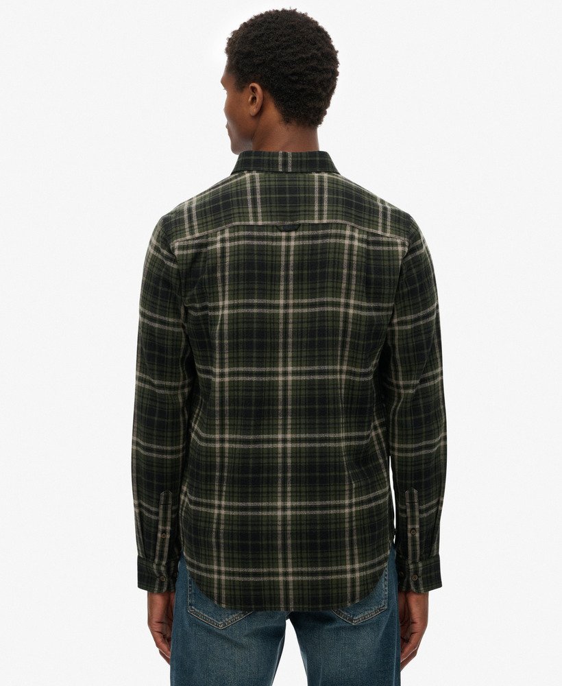 Man wearing a plaid shirt over a white t-shirt with a visible brand logo on a white background-Back view