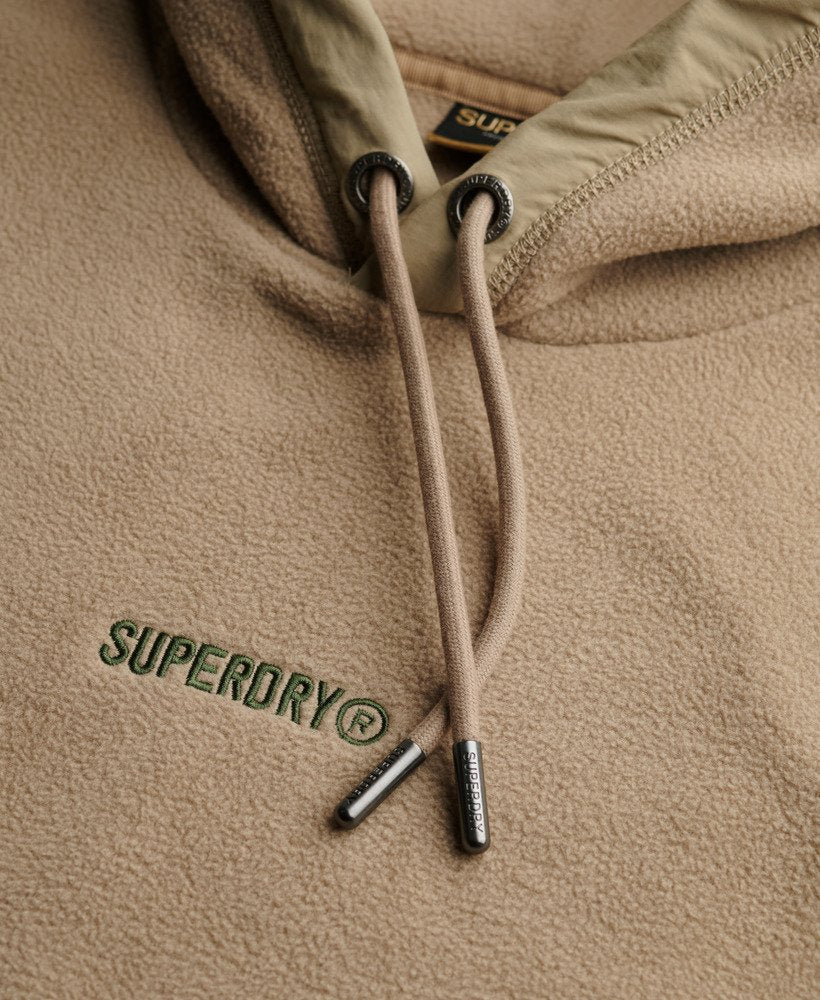 Close-up of a beige hoodie with Superdry logo and branding.