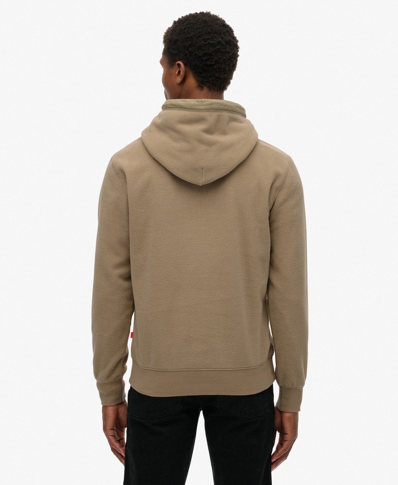Person wearing a beige hoodie from behind on a white background