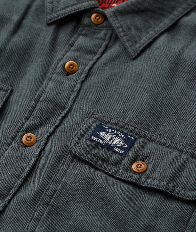 Close-up of a dark green jacket with brown buttons and a visible brand label.