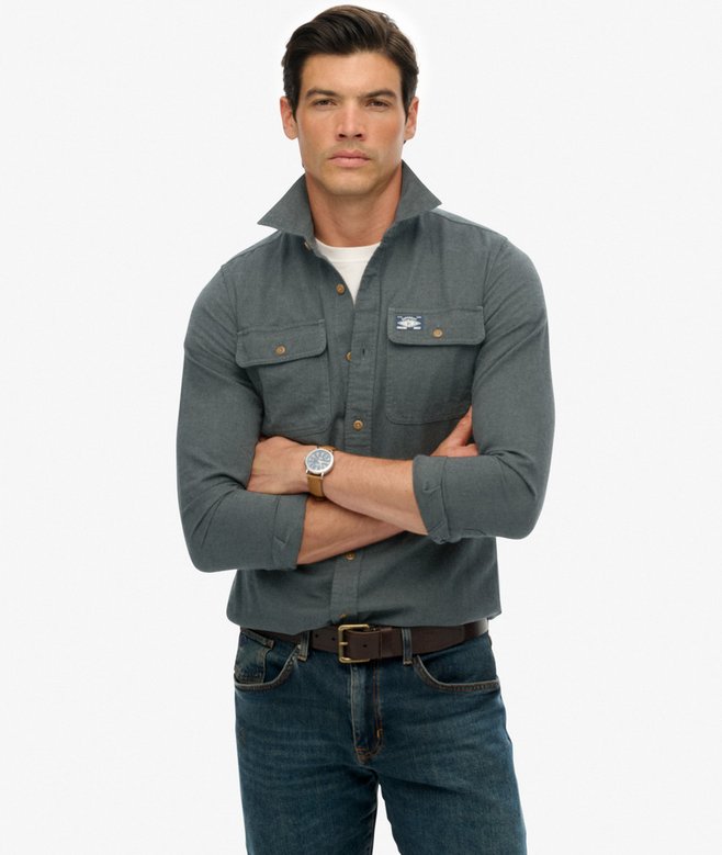 Man wearing a green shirt with a brand logo on a white background
