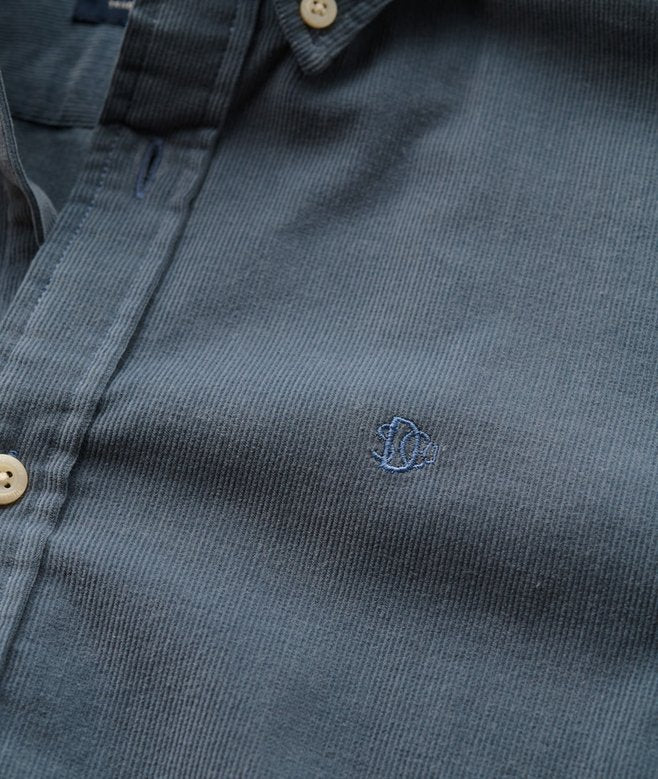 Close-up of a dark blue shirt with a small logo on the chest.
