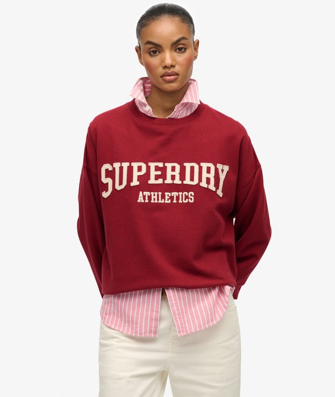 Person wearing a red Superdry Athletics sweatshirt on a white background