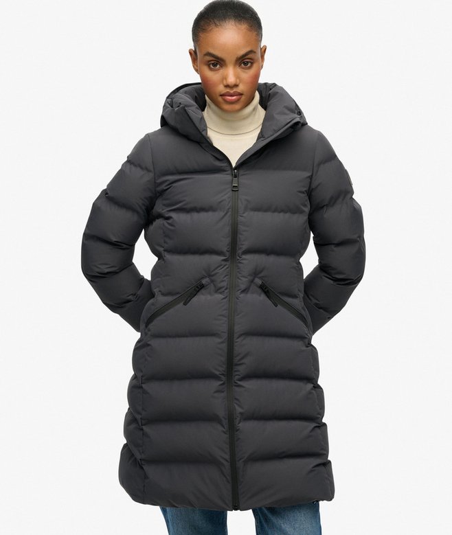 Person wearing a black puffer coat on a white background