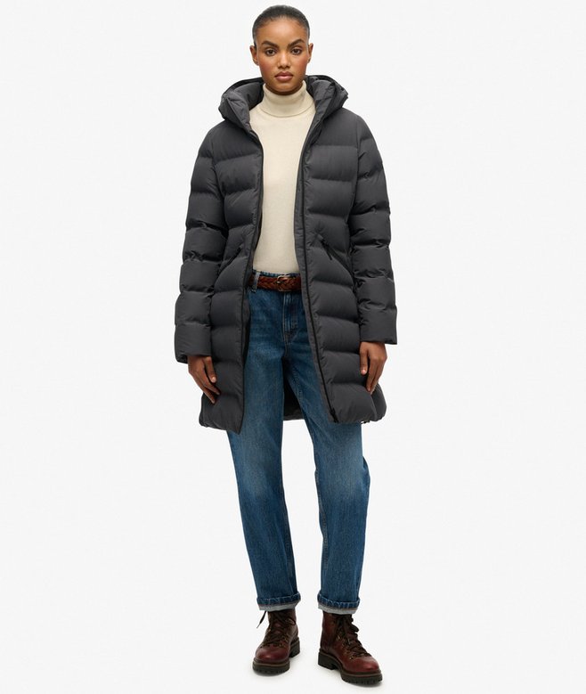 Person wearing a long puffer coat on a white background
