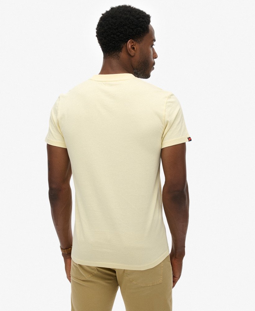 Man wearing a yellow t-shirt and pants on a white background