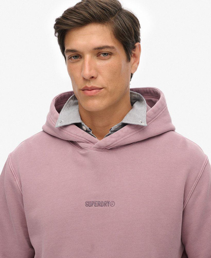 Man wearing a pink hoodie with 'Superdry' logo on a white background