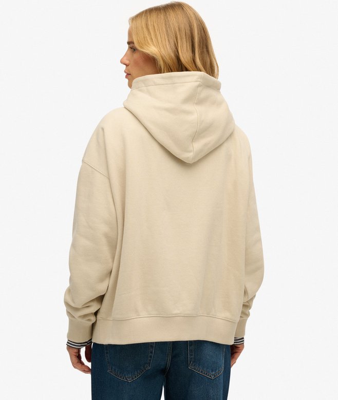 Person wearing a beige hoodie on a white background
