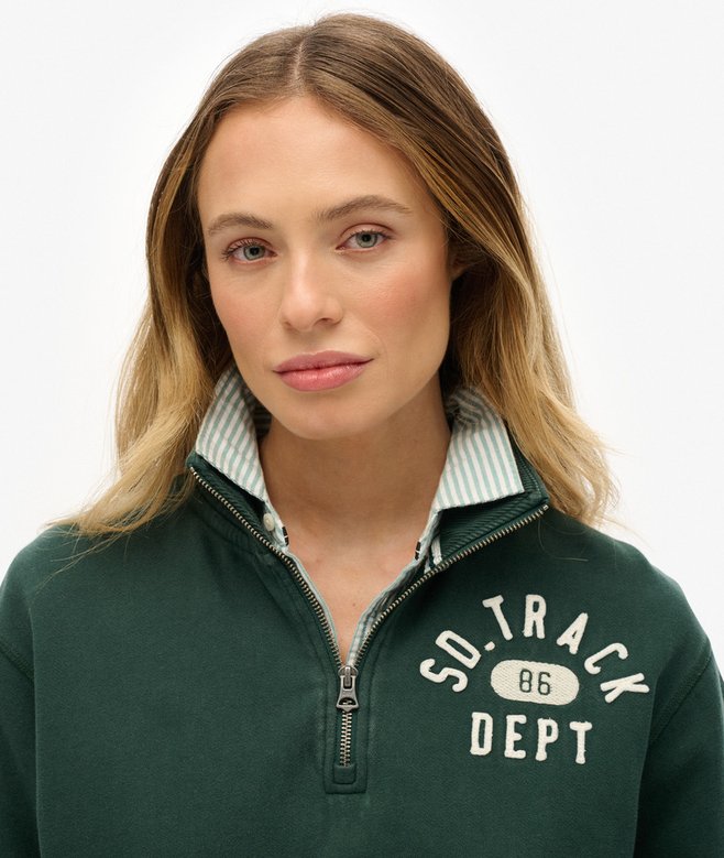 Woman wearing a green pullover with 'SD TRACK DEPT' text on a white background