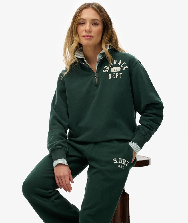 Woman wearing a green tracksuit with visible branding on a white background