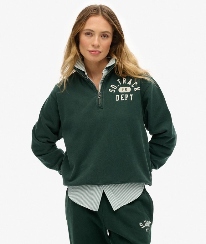 Woman wearing a green tracksuit with 'SD TRACK DEPT' text on a white background