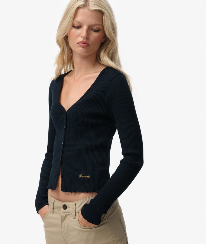 Woman wearing a navy cardigan with 'Guess' branding on a white background