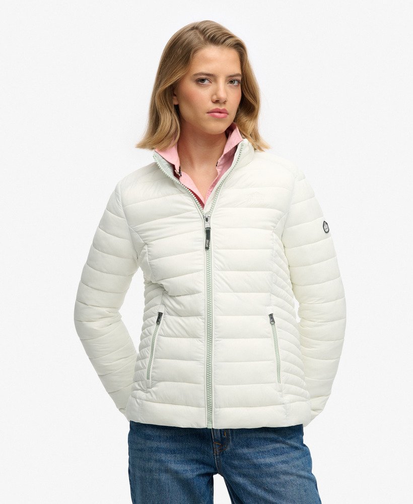 Woman wearing a white puffer jacket over a pink shirt on a white background