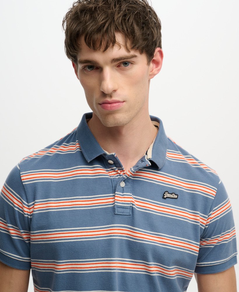 Man wearing a blue and orange striped polo shirt on a plain background