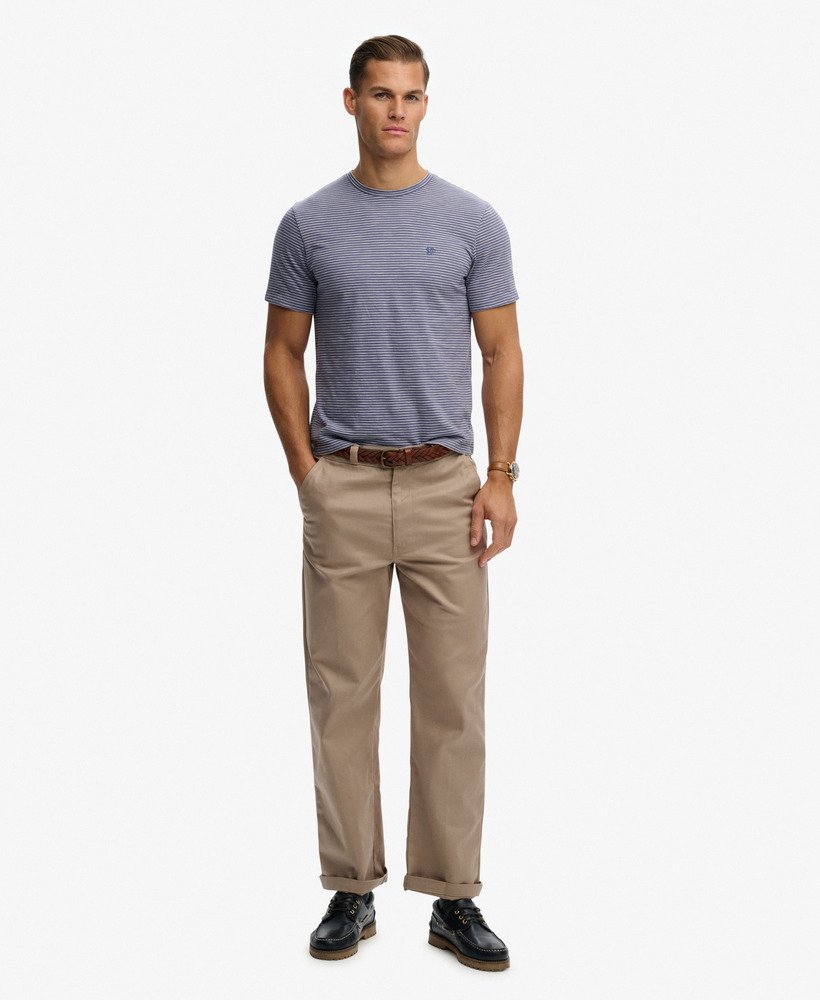 Man wearing a striped t-shirt and beige pants on a white background